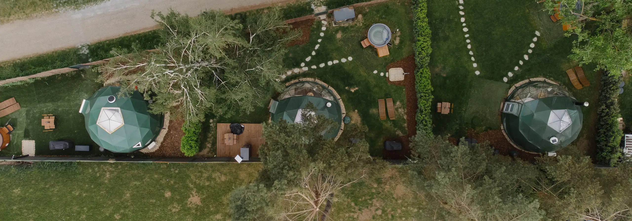 Aerial view of the three domes and garden at Unique Glamping Domes on Císařská louka